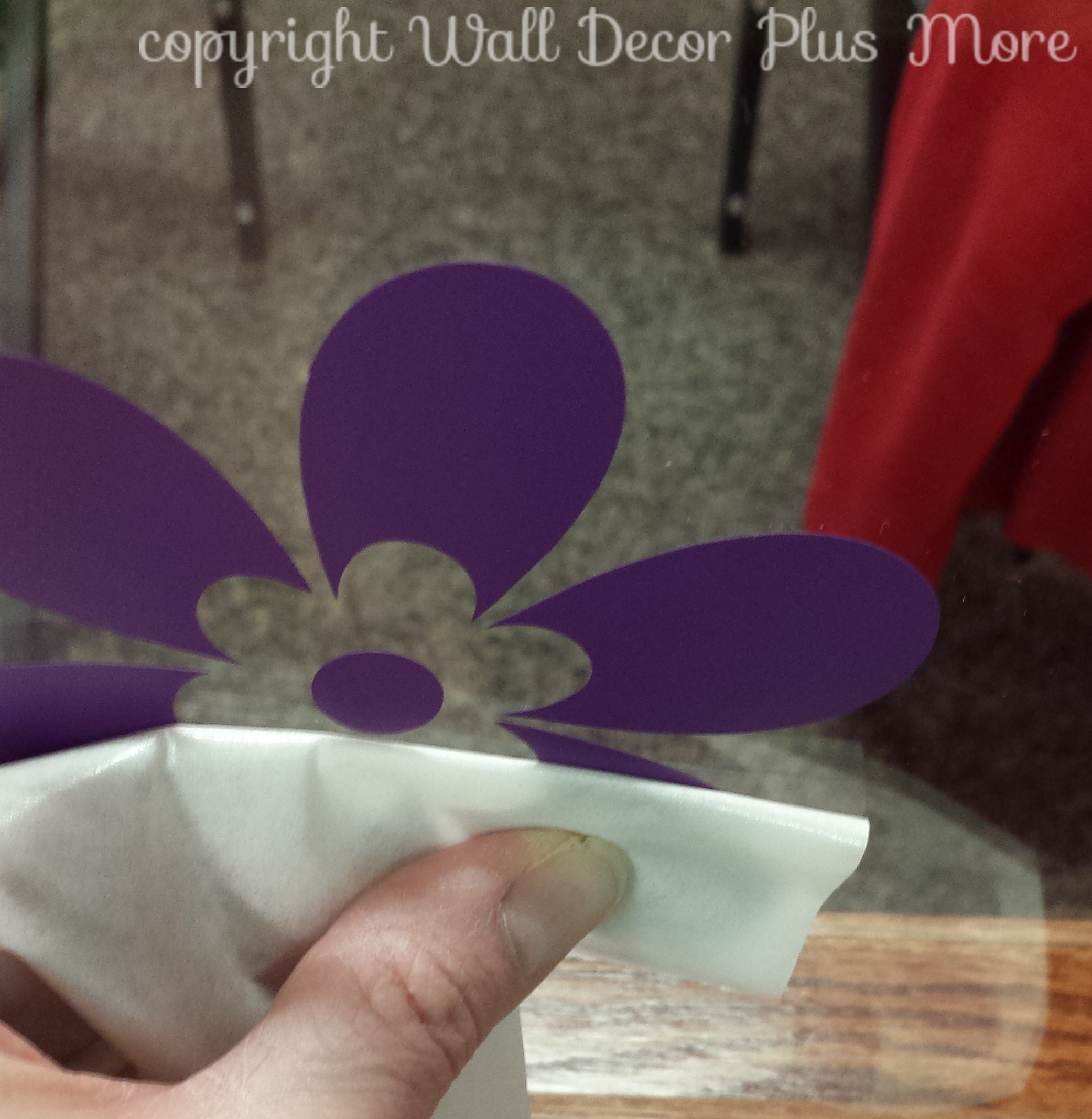 Peeling the top transfer paper off floral wall decals